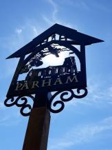 Parham's village sign featuring St Mary's Church, a B-17 Bomber and a pear tree 